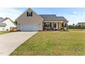 Charming single-Gathering home featuring an attached two-car garage and inviting covered front porch with rocking chairs at 50 Waterford Dr, Angier, NC 27501