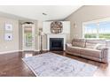 Comfortable living room with a cozy fireplace, complemented by hardwood floors and natural light from the large window at 50 Waterford Dr, Angier, NC 27501
