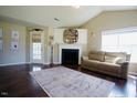 Bright living room with fireplace, hardwood floors, and a neutral-colored sofa underneath a vaulted ceiling at 50 Waterford Dr, Angier, NC 27501