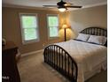 Cozy bedroom with a large bed, neutral walls, and two windows that provide great light at 501 Samara St, Apex, NC 27502