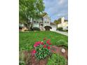 Beautiful home exterior with a lush lawn and vibrant pink flowers in the landscaping at 501 Samara St, Apex, NC 27502