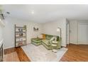 Living room showcasing a green couch, fireplace, bookcase and decor with hardwood floors at 503 Gooseneck Drive # B4, Cary, NC 27513