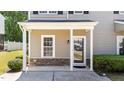 Inviting front porch featuring classic columns, stone accents, and a window with natural light, enhanced by manicured landscaping at 609 Woodson Dr, Clayton, NC 27527