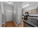 Bright entrance and kitchen featuring sleek black appliances, granite countertops, and wood-look flooring for modern appeal at 609 Woodson Dr, Clayton, NC 27527