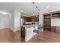 Open concept kitchen with stainless steel appliances, island with bar seating, and hardwood floors at 700 Finsbury St # 105, Durham, NC 27703