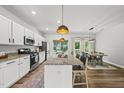 Open-concept kitchen with stainless steel appliances, a granite island, and pendant lighting at 77 Rolling Creek Cir, Clayton, NC 27520