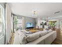 Spacious living room open to the kitchen, featuring a comfortable white sectional and modern light fixture at 77 Rolling Creek Cir, Clayton, NC 27520