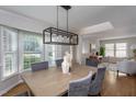 Inviting dining room with a modern chandelier and views of the landscaped yard at 802 Wakehurst Dr, Cary, NC 27519