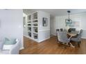 Open-concept space featuring a dining room, hardwood floors, and custom built-ins at 802 Wakehurst Dr, Cary, NC 27519