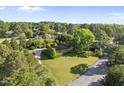 Beautiful aerial view of a home with a curved driveway, lush greenery, and mature trees, offering privacy and charm at 9 Lakeview Dr, Sanford, NC 27332