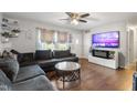 Cozy living room with a sectional sofa, hardwood floors, and a modern entertainment center with fireplace at 901 Currin Perry Rd, Zebulon, NC 27597