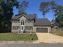 Charming two-story home featuring a well-manicured lawn, gray siding, and an attached garage at 9013 Tenderfoot Trl, Raleigh, NC 27615