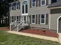 Close up of charming two-story home with detailed front porch and manicured landscaping at 9013 Tenderfoot Trl, Raleigh, NC 27615
