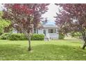 Quaint one-story home featuring a lush front yard and mature trees at 909 Goodwin Rd, Durham, NC 27712