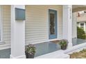 A close-up of the front porch showing flowerpots, a mailbox, a front door, and brick steps at 913 Washington St, Durham, NC 27701