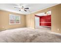 Bright living room featuring carpet flooring, ceiling fan, and an open layout for flexible living spaces at 919 Lexington Ct, Cary, NC 27511