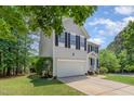 Two-story home showcasing a well-kept lawn, two-car garage, and traditional architectural details at 100 Full Moon Ct, Garner, NC 27529