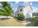Beautiful single Gathering home with landscaped front yard and front porch, with a view to a row of similar homes at 1009 Travern Dr, Raleigh, NC 27603