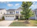 Charming two-story home featuring a well-manicured lawn, inviting front porch, and a convenient attached two-car garage at 1009 Travern Dr, Raleigh, NC 27603