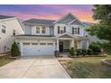 Charming two-story home featuring a well-manicured lawn, inviting front porch, and a convenient attached two-car garage at 1009 Travern Dr, Raleigh, NC 27603