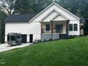 New construction with a welcoming front porch, two-car garage, and freshly laid grass at 101 Cochise Cv, Louisburg, NC 27549