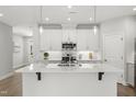 Modern kitchen with white cabinets, stainless steel appliances, and an island at 1011 Canary Pepper Dr, Durham, NC 27713