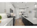 Well-lit kitchen boasts stainless appliances, a central island with a sink, and white cabinets at 1011 Canary Pepper Dr, Durham, NC 27713