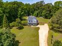 An aerial view shows the house, long driveway, and surrounding mature trees at 105 Kirkland Ct, Archer Lodge, NC 27527