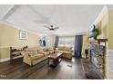 Cozy living room featuring a stone fireplace, ceiling fan, and comfortable seating area with natural light at 109 Winding Creek Dr, Youngsville, NC 27596