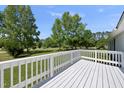 A white wood porch offers a lovely outdoor space with views of the green yard and trees beyond at 109 Winding Creek Dr, Youngsville, NC 27596