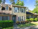Charming two-story townhome with tan siding, gray shutters, and manicured front yard at 11 Stone Village, Durham, NC 27704