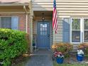 Inviting front entrance with a blue door, flower pots, and lush landscaping at 11 Stone Village, Durham, NC 27704