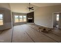 Bright living room boasting a cozy fireplace with stone accents and multiple windows for abundant natural light at 112 Royal Ave, Selma, NC 27576