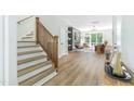 Open concept living room with hardwood floors, staircase, and view of outdoor patio at 1124 Upchurch St, Raleigh, NC 27610