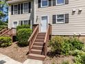 Inviting entrance stairs leading to a townhome with neutral siding and black shutters at 113 Weatherstone Dr # B, Chapel Hill, NC 27514