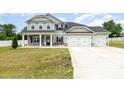 Charming two-story home featuring a stone-accented porch, a three-car garage, and a well-maintained front yard at `120 Red Hawk Pl, Smithfield, NC 27577