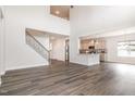 Open-concept living area with hardwood floors, a staircase, and a view of the modern kitchen at `120 Red Hawk Pl, Smithfield, NC 27577