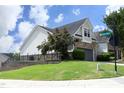Corner lot home featuring a side entry garage and lush lawn, complemented by street signage at 12306 Mossgreen St, Raleigh, NC 27614