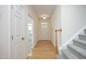 Bright foyer with hardwood floors, staircase, and white doors creating a welcoming entry at 12306 Mossgreen St, Raleigh, NC 27614