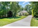 Beautifully landscaped home with mature trees and a long, paved driveway at 12733 Pamplona Dr, Wake Forest, NC 27587