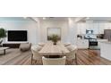 Sunlit dining room with modern table set next to kitchen with white cabinets at 1314 Rosepine Dr, Cary, NC 27519