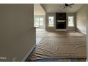 Bright living room with a cozy stone fireplace, large windows and ceiling fan at 134 Royal Ave, Selma, NC 27576