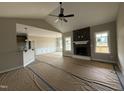 Open-concept living room featuring stone fireplace, large windows and view to dining and kitchen at 134 Royal Ave, Selma, NC 27576