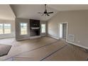 Spacious living room with a fireplace, vaulted ceilings, and large windows providing ample natural light at 134 Royal Ave, Selma, NC 27576