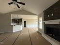 Open-concept living room featuring a vaulted ceiling, stone fireplace, and view to kitchen at 134 Royal Ave, Selma, NC 27576