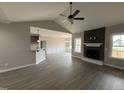 An open floor plan boasts luxury vinyl plank flooring and a fireplace with stone surround at 134 Royal Ave, Selma, NC 27576