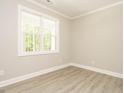 Bright, neutral bedroom featuring a large window and light wood-look flooring at 1481 Carolina Dr, Sanford, NC 27332