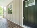 Close-up of a stylish front door with elegant hardware and a patterned porch floor at 1481 Carolina Dr, Sanford, NC 27332