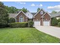 Attractive brick home with a two-car garage, complemented by lush green lawn and mature trees at 156 Yorkchester Way, Raleigh, NC 27615