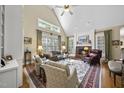 Elegant living room with vaulted ceilings, a fireplace, and abundant natural light from large windows at 156 Yorkchester Way, Raleigh, NC 27615